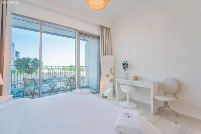 a bedroom with a bed and a desk and a balcony at Downtown Views II Tower 1 brand new units in Dubai