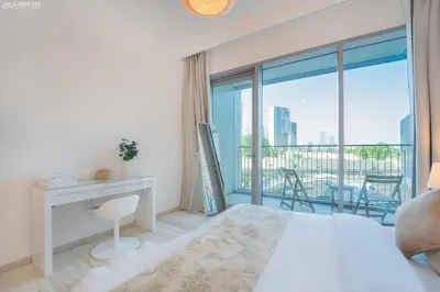 a bedroom with a bed and a desk and a balcony at Downtown Views II Tower 1 brand new units in Dubai