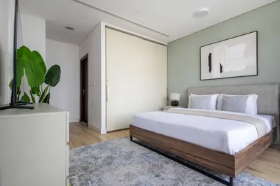a bedroom with a large bed and a television at Frank Porter - Burj Daman in Dubai
