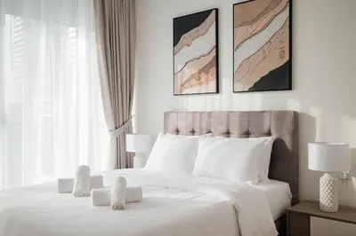 a white bedroom with a large bed with white pillows at 2BR 1 Residences Zabeel with Sleeps 5 - Luxury Stay in Dubai