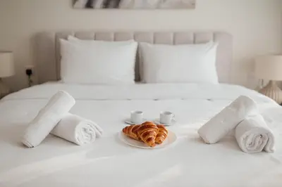a bed with towels and a plate of croissants and cups at 2BR 1 Residences Zabeel with Sleeps 5 - Luxury Stay in Dubai