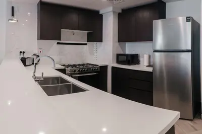a kitchen with a stainless steel refrigerator and cabinets at 2BR 1 Residences Zabeel with Sleeps 5 - Luxury Stay in Dubai