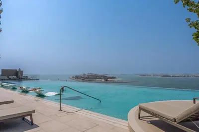 a swimming pool with a view of the water at Your beachfront luxe escape experience - Suiteable in Dubai