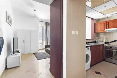 a kitchen with a washer and dryer in a room at StoneTree - Elegant Studio in Peaceful Community in Dubai