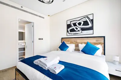 a bedroom with a large bed with blue and white pillows at Modern Style 1 BR near Marina Mall and Metro in Dubai