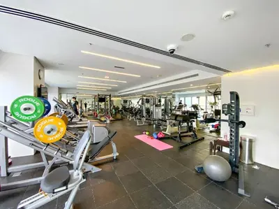 a gym with lots of machines and people in it at Modern Style 1 BR near Marina Mall and Metro in Dubai