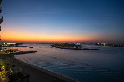 a view of a beach at sunset with the ocean at Palm View Paradise 3 bed apartment w private beach in Dubai