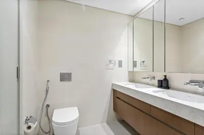 a white bathroom with a toilet and a sink at Palm View Paradise 3 bed apartment w private beach in Dubai