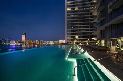 a large swimming pool in a city at night at Palm View Paradise 3 bed apartment w private beach in Dubai