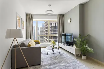 a living room with a couch and a tv at StoneTree - Unique 1BR Apartment in JLT in Dubai