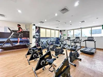 a gym with several treadmills and exercise bikes at StoneTree - Unique 1BR Apartment in JLT in Dubai