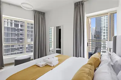 a bedroom with a large bed and a large window at StoneTree - Unique 1BR Apartment in JLT in Dubai