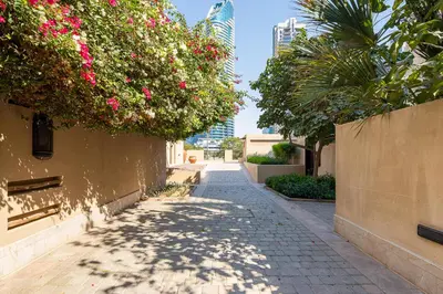 a sidewalk with pink flowers on a building at Frank Porter - Reehan 1 in Dubai