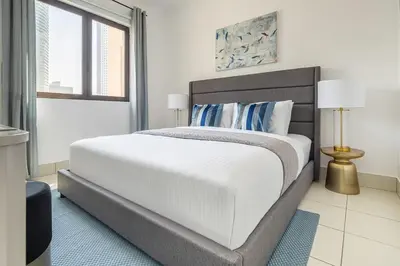 a white bedroom with a large white bed and a window at Frank Porter - Reehan 1 in Dubai