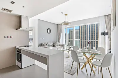 a kitchen and living room with a table and chairs at StoneTree - Fabulous 1BR Apartment in Dubai Marina in Dubai
