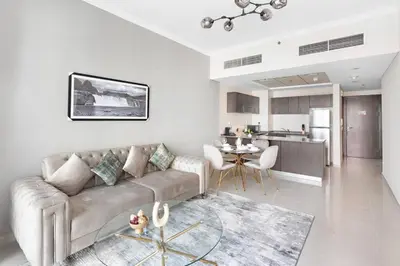 a living room with a couch and a table and a kitchen at StoneTree - Modern 1 BR Apartment in Dubai Marina in Dubai