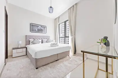 a white bedroom with a bed and a glass table at StoneTree - Modern 1 BR Apartment in Dubai Marina in Dubai