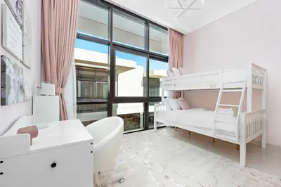 a white bedroom with a bunk bed and a desk at StoneTree - The Modern Family Friendly Villa in Dubai