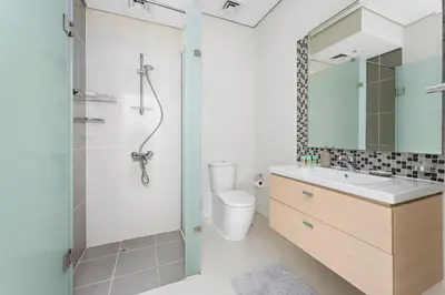 a bathroom with a shower and a toilet and a sink at StoneTree - The Modern Family Friendly Villa in Dubai
