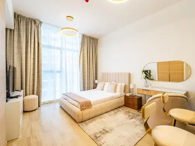 a hotel room with a bed and a table at Comfy and stylish Studio in Regina Towers - JVC in Dubai