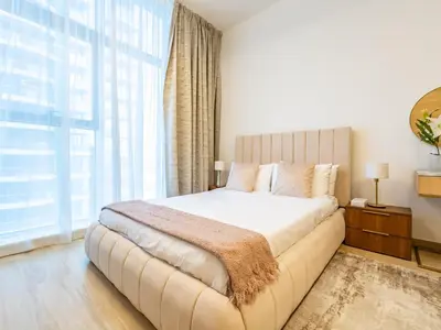 a bedroom with a large bed with a large window at Comfy and stylish Studio in Regina Towers - JVC in Dubai