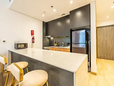 a kitchen with a counter and a refrigerator at Comfy and stylish Studio in Regina Towers - JVC in Dubai
