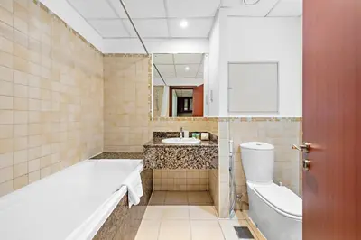 a bathroom with a tub and a toilet and a sink at Sleek Studio in JBR with Pool & Dubai Skyline View in Dubai