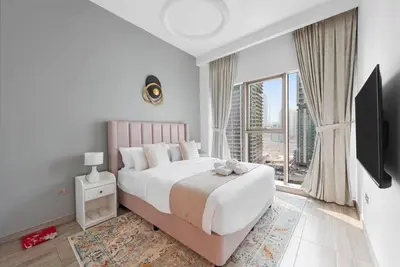 a bedroom with a large bed and a large window at StoneTree - Stylish 1BR Apartment in MBL Residence in Dubai
