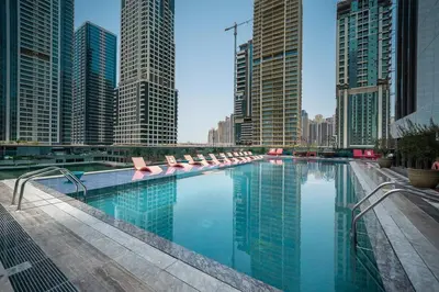 a large swimming pool in a city with tall buildings at StoneTree - Stylish 1BR Apartment in MBL Residence in Dubai