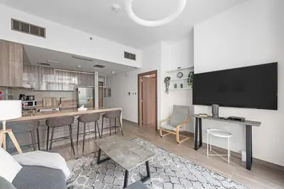 a living room with a bar and a kitchen at StoneTree - Stylish 1BR Apartment in MBL Residence in Dubai
