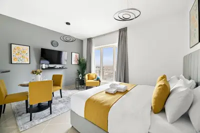 a bedroom with a large bed and a dining room at StoneTree - NEW Furnished Studio in JLT in Dubai