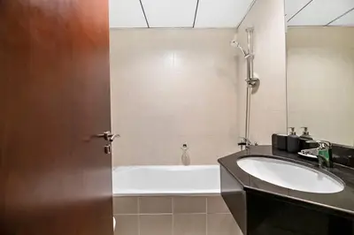 a bathroom with a bath tub and a sink at StoneTree - NEW Furnished Studio in JLT in Dubai