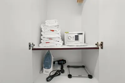 a shelf with a microwave and a pile of towels at StoneTree - NEW Furnished Studio in JLT in Dubai
