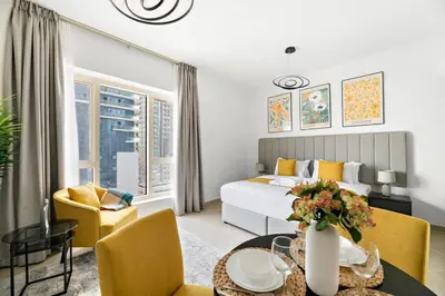 a bedroom with a bed and a table and chairs at StoneTree - NEW Furnished Studio in JLT in Dubai