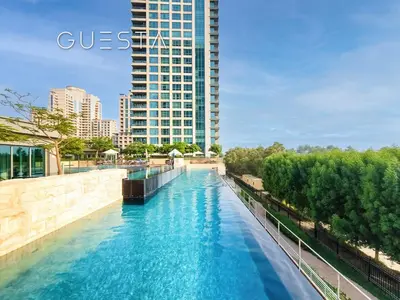 a river in a city with a tall building at Fairways Tower by Emaar, The Views and Greens in Dubai