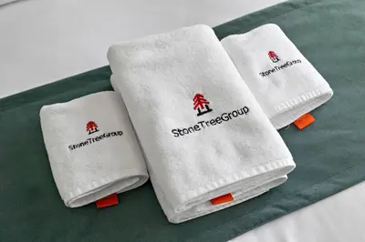 three white towels sitting on top of a green table at StoneTree - NEW Modern 1BR in JLT in Dubai