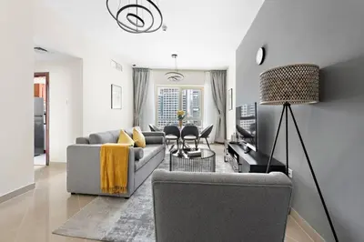 a living room with a couch and a table at StoneTree - Furnished 1BR with Modern Design in Dubai