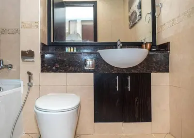 a bathroom with a sink and a toilet and a mirror at StoneTree - Family-friendly Studio in Peaceful Community in Dubai