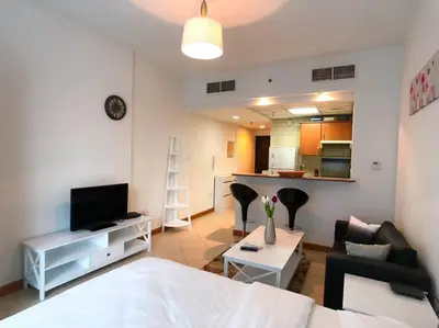a room with a bed and a living room at StoneTree - Prime Location - Furnished Studio - Near Metro in Dubai