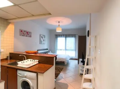 a kitchen with a washer and a room with a bed at StoneTree - Prime Location - Furnished Studio - Near Metro in Dubai