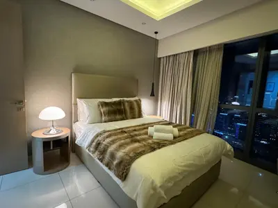 a bedroom with a large bed and a window at ROYAL APARTMENTS By Damac Paramount Towers B Burj Khalifa Views in Dubai