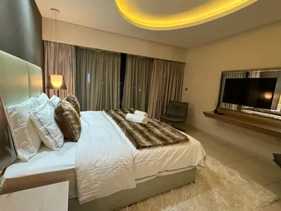 a bedroom with a large bed and a tv at ROYAL APARTMENTS By Damac Paramount Towers B Burj Khalifa Views in Dubai