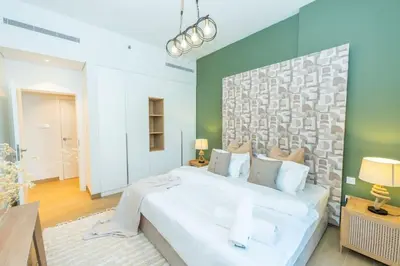 a bedroom with a large white bed and a green wall at Azure Escape !Joyful 1 Bed Apartment close to the Sea! in Dubai