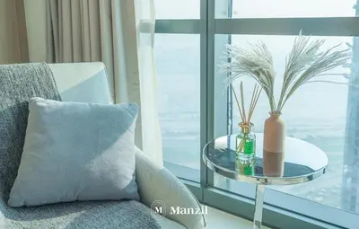 a table with a vase on it next to a window at Manzil - Stunning 3BR Apt in Paramount nr Burj in Dubai