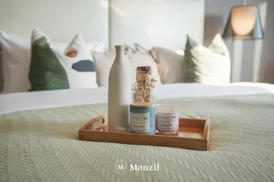 a tray with bottles and a glass on a bed at Manzil - Stunning 3BR Apt in Paramount nr Burj in Dubai