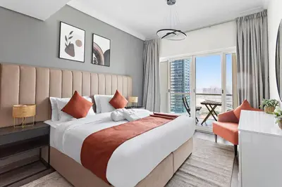 a bedroom with a large bed and a large window at StoneTree - Amazing 1BR with Lake View in Dubai