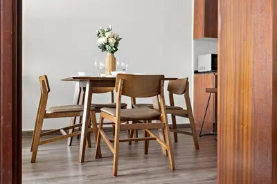 a dining room table and chairs with a vase of flowers at StoneTree - Amazing 1BR with Lake View in Dubai