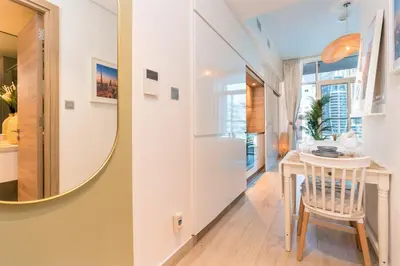 a small kitchen with a round mirror and a table at Stunning Apt with Balcony & Marina View in Dubai