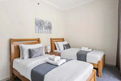 a room with two twin beds with white sheets at Breathtaking Marina View - Spacious Apartment in Dubai