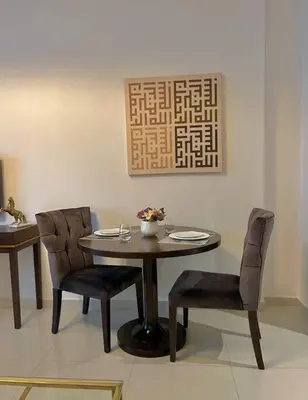 a table and two chairs and a table and a picture at Ghalia Damac Studio Apartment in Dubai